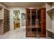 Spacious walk-in closet with sauna and vanity with light wood cabinets, drawers and stone countertop at 9722 E Mark Ln, Scottsdale, AZ 85262