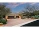 A contemporary desert home with a two-car garage, mature landscaping, and private gated entrance at 9722 E Mark Ln, Scottsdale, AZ 85262