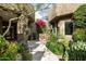 Beautiful home entrance featuring stone accents, lush desert landscaping, and a charming courtyard at 9722 E Mark Ln, Scottsdale, AZ 85262