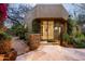 Home's entrance showing desert landscape, bougainvillea, cactus and stone wall at 9722 E Mark Ln, Scottsdale, AZ 85262