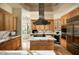 Gourmet kitchen features custom cabinets, a center island, and stainless steel appliances at 9722 E Mark Ln, Scottsdale, AZ 85262