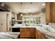 A gourmet kitchen features marble countertops, modern appliances, and an open layout with a fireplace in the background at 9722 E Mark Ln, Scottsdale, AZ 85262