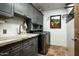 Laundry room with gray cabinets, marble countertop, stainless steel appliances and tile flooring at 9722 E Mark Ln, Scottsdale, AZ 85262