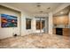 Open living area with tiled floors, wet bar with cabinets and a sliding glass door at 9722 E Mark Ln, Scottsdale, AZ 85262