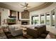 The living room features a stone fireplace, ceiling fan, outdoor access, and stylish furniture at 9722 E Mark Ln, Scottsdale, AZ 85262
