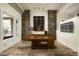 Bright office with stone accents, a large desk, and a calming view of the outside at 9722 E Mark Ln, Scottsdale, AZ 85262
