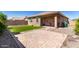 Backyard featuring artificial turf, paver patio, rock landscape, and covered patio at 12351 W Palmaire Ave, Glendale, AZ 85307