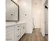 Bathroom vanity featuring dual sinks, white cabinets, and a large mirror at 12351 W Palmaire Ave, Glendale, AZ 85307