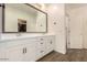 Bathroom vanity with dual sinks, white cabinets, and a large mirror at 12351 W Palmaire Ave, Glendale, AZ 85307