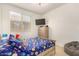 Bedroom with space-themed decor, including a TV and bed with colorful bedding at 12351 W Palmaire Ave, Glendale, AZ 85307