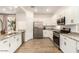 Bright and modern kitchen with stainless steel appliances, granite countertops, and white cabinetry at 12351 W Palmaire Ave, Glendale, AZ 85307