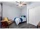 Cozy bedroom featuring wood floors, a ceiling fan, and comfortable seating at 12756 N 88Th Ave, Peoria, AZ 85381