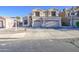 Two-story home featuring a beige stucco exterior, a three-car garage and a well-maintained front yard at 12905 W Crocus Dr, El Mirage, AZ 85335