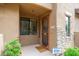 Inviting front entrance with an intricate security door, desert landscaping, and a visible security system at 13300 E Via Linda -- # 1054, Scottsdale, AZ 85259