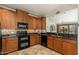 Well-equipped kitchen with dark countertops, a black double oven, and warm wooden cabinetry at 13300 E Via Linda -- # 1054, Scottsdale, AZ 85259