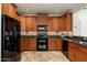 Modern kitchen featuring black appliances, mosaic backsplash, and warm wood cabinetry at 13300 E Via Linda -- # 1054, Scottsdale, AZ 85259