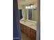 Bathroom featuring double sinks, wood cabinets, large mirror, and updated lighting fixtures at 1449 E Highland Ave # 39, Phoenix, AZ 85014