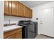 Functional laundry room with cabinetry, a utility sink, and modern washer and dryer units at 16113 E Andrew Dr, Fountain Hills, AZ 85268