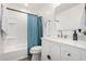 Modern bathroom featuring a white vanity, black hardware, and a tub with blue shower curtain at 16567 N Slate Ln, Maricopa, AZ 85139