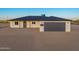 Charming single-story home featuring a gray garage door, minimalist landscaping, and stylish exterior lighting at 16567 N Slate Ln, Maricopa, AZ 85139