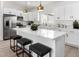 Modern kitchen with white cabinets, stainless steel appliances, and a quartz countertop island with seating at 16567 N Slate Ln, Maricopa, AZ 85139