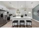 Bright kitchen featuring white cabinets, a central island with bar seating and modern appliances at 16567 N Slate Ln, Maricopa, AZ 85139