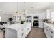 Open kitchen with marble countertops, stainless steel appliances, white cabinets, and brass accents at 16567 N Slate Ln, Maricopa, AZ 85139
