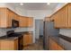 Well-equipped kitchen featuring wood cabinets, dark countertops, and stainless steel appliances at 16600 N Thompson Peak Pkwy # 1072, Scottsdale, AZ 85260