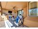 Inviting covered balcony with comfortable seating, desert views, and an outdoor kitchen with a grill and TV at 17025 E La Montana Dr # 123, Fountain Hills, AZ 85268