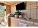 Covered balcony featuring an outdoor kitchen with a grill, sink, tv and desert views at 17025 E La Montana Dr # 123, Fountain Hills, AZ 85268