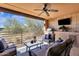 Stylish covered balcony with outdoor kitchen, TV, comfortable seating, ceiling fan, and peaceful desert views at 17025 E La Montana Dr # 123, Fountain Hills, AZ 85268