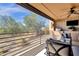 Covered balcony with an outdoor kitchen featuring a grill, sink, and tv overlooking desert landscaping at 17025 E La Montana Dr # 123, Fountain Hills, AZ 85268