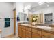 Bathroom with double sinks, wooden cabinets, granite countertops, and a glass enclosed shower at 17025 E La Montana Dr # 123, Fountain Hills, AZ 85268