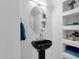 Modern powder room featuring a black pedestal sink, round mirror, and built-in display shelving at 17025 E La Montana Dr # 123, Fountain Hills, AZ 85268