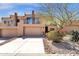 Charming two-story home featuring a tandem two car garage, balcony, and desert landscaping at 17025 E La Montana Dr # 123, Fountain Hills, AZ 85268