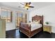 The main bedroom features a dark wood bed frame, neutral tones, and shuttered windows at 17025 E La Montana Dr # 123, Fountain Hills, AZ 85268