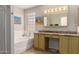 Bright bathroom with double sinks, a soaking tub, and neutral decor at 1741 S Clearview Ave # 70, Mesa, AZ 85209