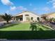 Private backyard with artificial turf, covered patio, and desert landscaping at 17494 N Maddaloni Ave, Maricopa, AZ 85138