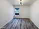 This empty bedroom has hard floors, a window, and a ceiling light at 17494 N Maddaloni Ave, Maricopa, AZ 85138