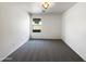 This empty bedroom has neutral carpet, a window, and a ceiling light at 17494 N Maddaloni Ave, Maricopa, AZ 85138