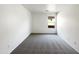 This empty bedroom has neutral carpet, a window, and a ceiling light at 17494 N Maddaloni Ave, Maricopa, AZ 85138