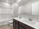 Bathroom featuring a double sink vanity, a tub with tiled walls, and stylish flooring at 17621 W Pierson St, Goodyear, AZ 85395
