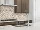 Detailed view of the kitchen featuring quartz countertops, stainless steel sink, and cooktop at 17621 W Pierson St, Goodyear, AZ 85395