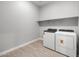 Bright laundry room with brand new white washer and dryer and a convenient overhead shelf at 17621 W Pierson St, Goodyear, AZ 85395