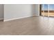 An empty living room with clean neutral walls and new tile flooring with outdoor view at 17621 W Pierson St, Goodyear, AZ 85395