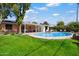 Beautiful backyard with lush green grass, mature trees, and a sparkling pool at 1939 E Solano Dr, Phoenix, AZ 85016