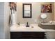 Updated bathroom featuring modern sink and vanity, decorative mirror and convenient toiletry shelving at 1939 E Solano Dr, Phoenix, AZ 85016