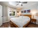 Cozy bedroom with wood floors, large window, and a modern ceiling fan at 1939 E Solano Dr, Phoenix, AZ 85016