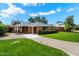 Charming brick home with well-manicured lawn and a long driveway leading to covered parking area at 1939 E Solano Dr, Phoenix, AZ 85016