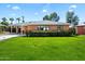 Charming single-story brick home featuring a well-manicured lawn, carport, and trimmed hedge landscaping at 1939 E Solano Dr, Phoenix, AZ 85016